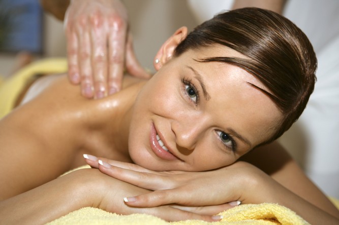 woman lying on a treatment table enjoying a massage on her back