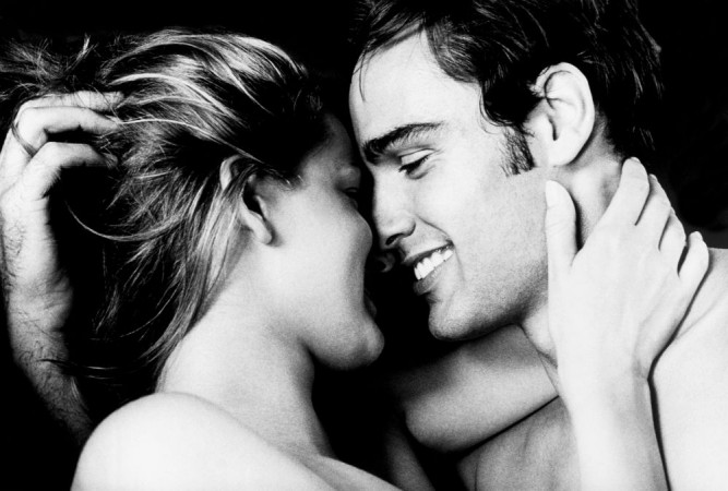 smiling naked couple lying on bed
