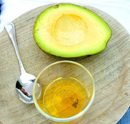 woman lying ob bed with tray on her belly with avocado fruit