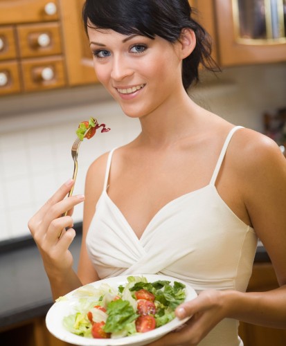 Young woman in kitchen eating her meal