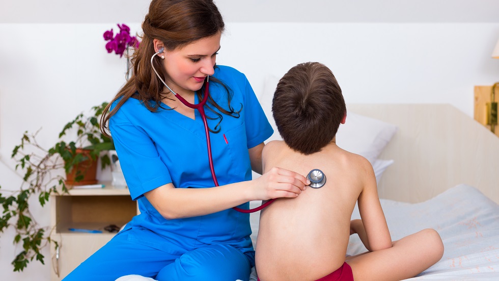 O doctorita consulta un copil la plamani