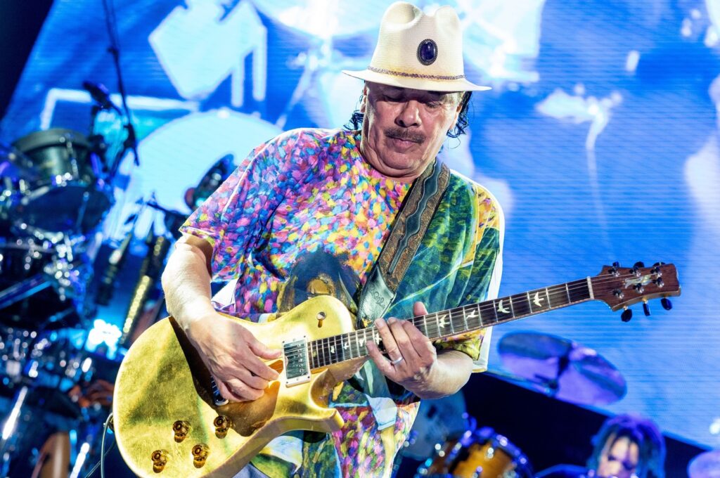Santana, cu o camasa colorata, cantand la chitara intr-un concert din Nashville